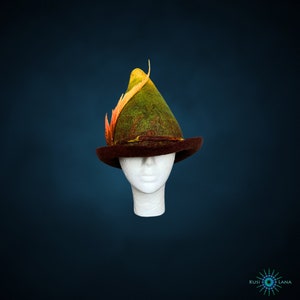 May include: A green and brown felt hat with a yellow and orange feather. The hat is on a white mannequin head.