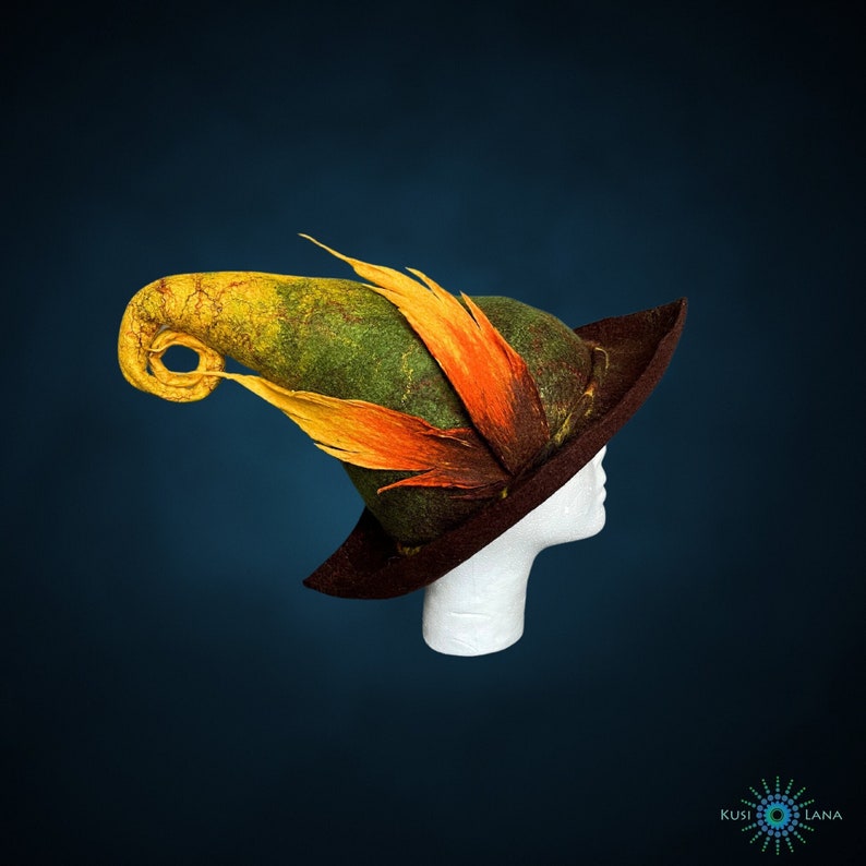 May include: A green, brown, and orange felt witch hat with a curled brim and a long, pointed, curled top. The hat is on a white mannequin head.