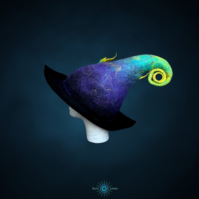 May include: A blue and green felt witch hat with a curled brim and a yellow accent. The hat is on a white mannequin head.