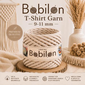 Könnte beinhalten: Eine zylindrische Spule aus beigem T-Shirt-Garn mit der Aufschrift Bobilon und einer Stärke von 9-11 mm. Das Garn ist zu einer dicken, durchgehenden Schnur gewickelt. Das Etikett zeigt den Markennamen Bobilon und kleine Bilder von Bastelprojekten.