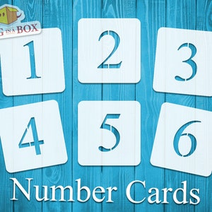 Può includere: Sei stencil numerici bianchi su uno sfondo di legno blu. Gli stencil sono a forma di quadrati e ognuno ha un numero da 1 a 6 ritagliato. Il testo "Number Cards" è stampato sotto gli stencil.