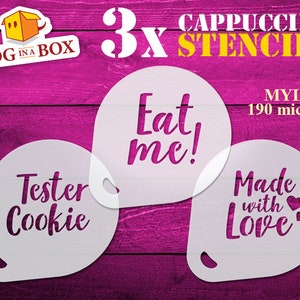 May include: Three white cappuccino stencils with the text "Tester Cookie", "Eat me!" and "Made with Love" on a pink wooden background. The stencils are made of 190 micron mylar.