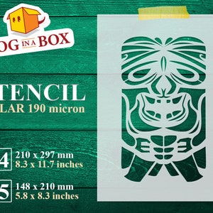 May include: A white stencil featuring a stylized tiki mask design. The stencil is made of MYLAR 190 micron material. The image includes the text "STENCIL" and size details: A4 (8.3 x 11.7 inches) and A5 (5.8 x 8.3 inches). The logo "DOG IN A BOX" is in the upper left corner.