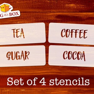 Könnte beinhalten: Satz von vier weißen Schablonen mit den Wörtern "TEA", "COFFEE", "SUGAR" und "COCOA" in einer handschriftlichen Schriftart. Die Schablonen befinden sich auf einem Holzgrund.