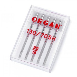 Könnte beinhalten: Eine Packung mit fünf silbernen Nähmaschinennadeln in einem durchsichtigen Kunststoffbehälter. Die Nadeln sind mit "ORGAN 130/705H 90/14" beschriftet.