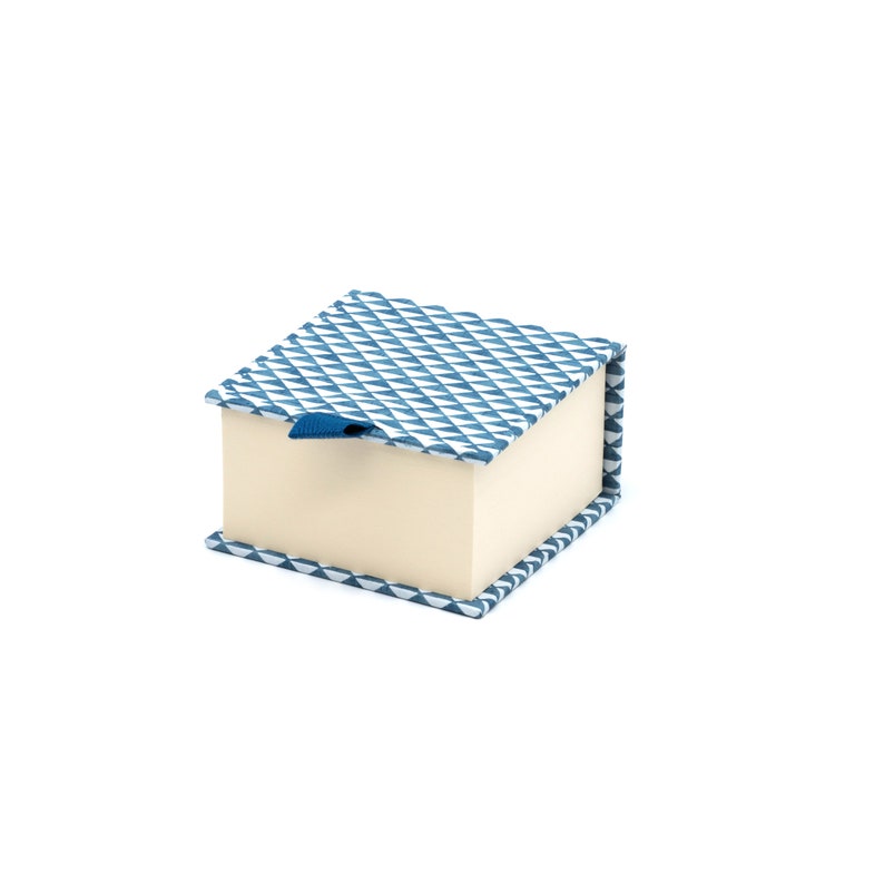 May include: A small, square, blue and white patterned gift box with a blue ribbon.