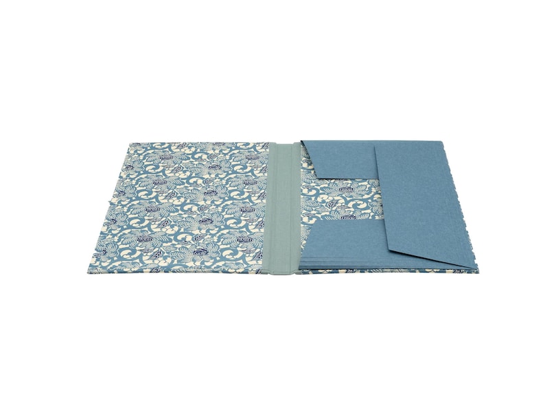 Handgefertigte Sammelmappe mit Japanpapier bezogen und mit strapazierfähigem Bucheinbandgewebe eingefasst. Im Inneren schützen drei eingearbeitete Klappen den Inhalt zuverlässig vor dem Herausfallen. Ein Gummizugband hält die Mappe sicher verschlossen. Ideal für Zeichnungen, Dokumente, Briefe und andere kreative Arbeiten. Es besteht die Möglichkeit zur Personalisierung.