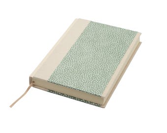 Op de afbeelding: Een notitieboek met harde kaft, voorzien van een crèmekleurige rug en een saliegroen voorpaneel met een wit spikkelpatroon. Het notitieboek bevat een dun, bijpassend crèmekleurig lint als bladwijzer dat uit de onderkant van de rug steekt.