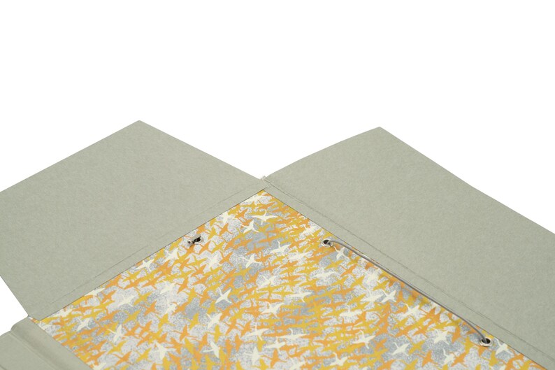 Handgefertigte Sammelmappe mit Japanpapier bezogen und mit strapazierfähigem Bucheinbandgewebe eingefasst. Im Inneren schützen drei eingearbeitete Klappen den Inhalt zuverlässig vor dem Herausfallen. Ein Gummizugband hält die Mappe sicher verschlossen. Ideal für Zeichnungen, Dokumente, Briefe und andere kreative Arbeiten. Es besteht die Möglichkeit zur Personalisierung.