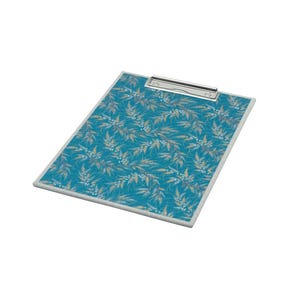 May include: A rectangular clipboard featuring a vibrant teal background adorned with a repeating pattern of delicate, light-colored wheat stalks and small white flowers. The board includes a silver-toned metal clip at the top edge.
