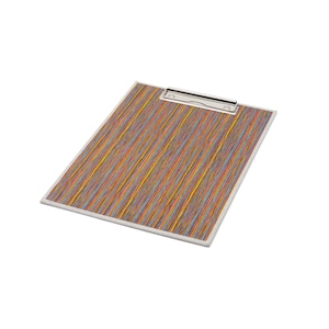 May include: A rectangular clipboard featuring a vibrant pattern of thin, vertical multicolored stripes in shades of orange, yellow, blue, and red. The board is topped with a silver-toned metal clip mechanism designed to hold papers securely in place.