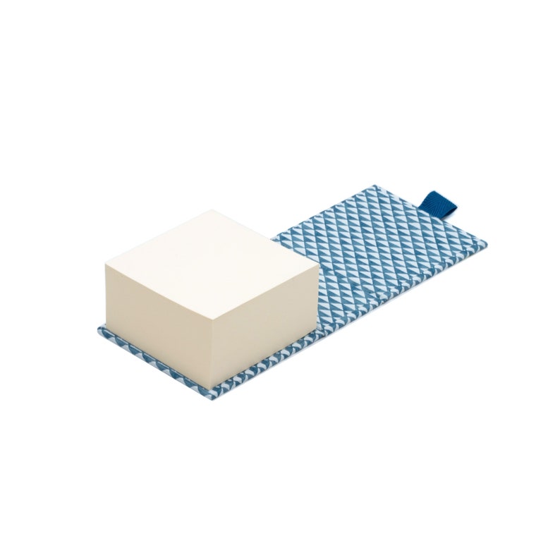 May include: A blue and white patterned notepad with a stack of white sticky notes. The notepad has a blue tab.