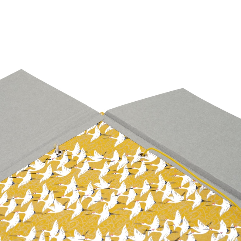 Handgefertigte Sammelmappe mit Japanpapier bezogen und mit strapazierfähigem Bucheinbandgewebe eingefasst. Im Inneren schützen drei eingearbeitete Klappen den Inhalt zuverlässig vor dem Herausfallen. Ein Gummizugband hält die Mappe sicher verschlossen. Ideal für Zeichnungen, Dokumente, Briefe und andere kreative Arbeiten. Es besteht die Möglichkeit zur Personalisierung.