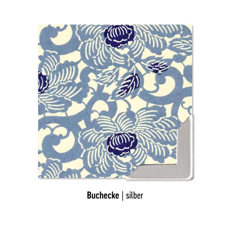 Pode incluir: Um protetor de canto de livro quadrado com fundo creme e um padr&atilde;o repetitivo de motivos florais estilizados e vinhas em tons de azul e azul-marinho escuro. A pe&ccedil;a de canto tem um acabamento met&aacute;lico prateado na borda interna.