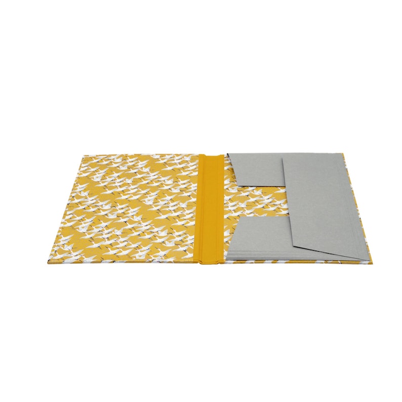 Handgefertigte Sammelmappe mit Japanpapier bezogen und mit strapazierfähigem Bucheinbandgewebe eingefasst. Im Inneren schützen drei eingearbeitete Klappen den Inhalt zuverlässig vor dem Herausfallen. Ein Gummizugband hält die Mappe sicher verschlossen. Ideal für Zeichnungen, Dokumente, Briefe und andere kreative Arbeiten. Es besteht die Möglichkeit zur Personalisierung.