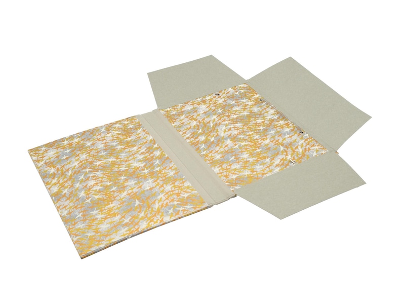 Handgefertigte Sammelmappe mit Japanpapier bezogen und mit strapazierfähigem Bucheinbandgewebe eingefasst. Im Inneren schützen drei eingearbeitete Klappen den Inhalt zuverlässig vor dem Herausfallen. Ein Gummizugband hält die Mappe sicher verschlossen. Ideal für Zeichnungen, Dokumente, Briefe und andere kreative Arbeiten. Es besteht die Möglichkeit zur Personalisierung.