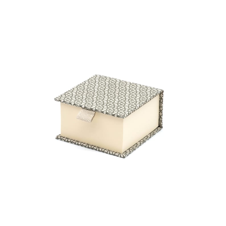 May include: A small, square box with a white and green patterned lid. The box has a cream-colored interior and a white ribbon pull.
