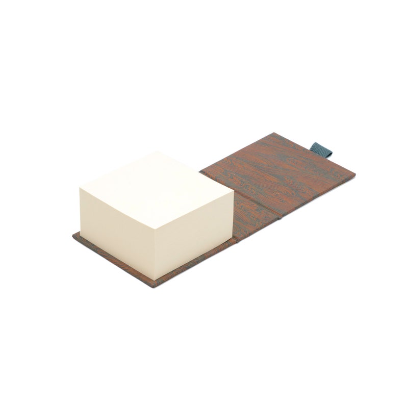 May include: A brown faux wood notepad with a black elastic band closure. The notepad is open and the top sheet of paper is visible.