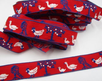 Könnte beinhalten: Rotes Band mit einem sich wiederholenden Muster aus weißen Enten, blauen Vogelhäusern und Bäumen. Das Band ist mit einem detaillierten Design bestickt, ideal für Bastelarbeiten und Verzierungen. Das Band ist aufgerollt und zeigt das Muster.