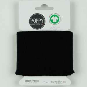 Könnte beinhalten: Ein schwarzes, geripptes Stoffband, wahrscheinlich für Kleidung oder Accessoires, wird auf einem weißen Produktanhänger präsentiert. Der Anhänger zeigt den Markennamen "POPPY" und den Text "designed for you". Der Anhänger enthält auch die Zertifizierungen "OEKO-TEX" und "GOTS". Das Band ist 135 cm lang.