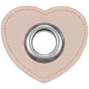 Op de afbeelding: Een lichtroze hartvormige leren patch met een zilveren metalen oogje in het midden.