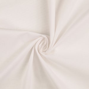 Puede incluir: Tela blanca con una textura suave y lisa. La tela está doblada y drapeada, creando un aspecto fluido y elegante.