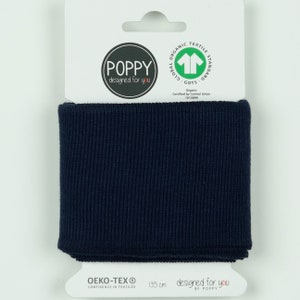 Könnte beinhalten: Ein 135 cm langer, gerippter Strickbund in Marineblau mit dem Text "designed for you by POPPY" und dem Logo "POPPY designed for you". Der Bund ist GOTS- und OEKO-TEX-zertifiziert.