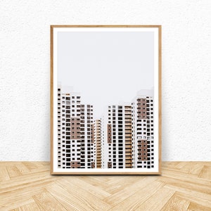 May include: A framed print featuring a minimalist architectural photograph. The image showcases several high-rise apartment buildings with white facades and brown accents. The buildings are set against a plain, light-colored background.