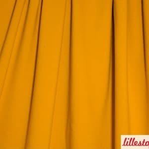 Könnte beinhalten: Nahaufnahme eines glatten, senfgelben Stoffes. Der Stoff ist gefaltet und hat einen leichten Glanz.