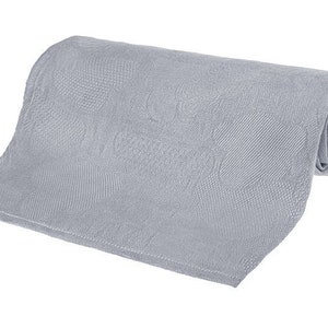 Peut inclure: Une couverture rectangulaire en tissu gris clair texturé, roulée. La couverture est faite d'un tissu doux et tissé.