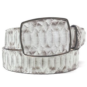 May include: A stylish, light gray belt with a textured snakeskin pattern. The belt features a rectangular silver buckle. The design is neutral and suitable for various outfits. The belt is a fashion accessory.