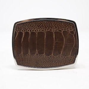 May include: A brown ostrich leather belt buckle with a silver metal frame.
