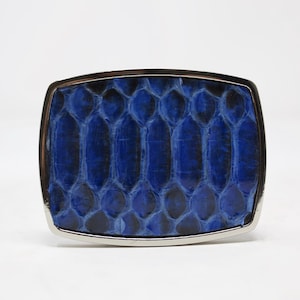 May include: A blue snakeskin belt buckle with a silver metal frame.