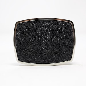 May include: A black leather belt buckle with a silver metal frame.