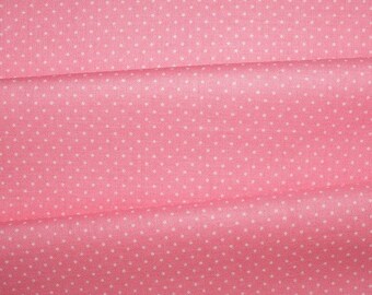 Könnte beinhalten: Rosa Stoff mit weißen Polka Dots. Der Stoff ist gefaltet, wodurch Schatten und Texturen entstehen. Die Polka Dots sind gleichmäßig verteilt und verleihen dem Design einen spielerischen Aspekt. Geeignet für Nähprojekte, wirkt der Stoff weich und einladend.
