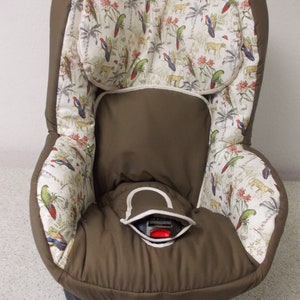 Puede incluir: Una funda para asiento de coche de color marrón y blanco con un diseño de pájaros tropicales. La funda está hecha de un tejido suave y cómodo y tiene un reposacabezas incorporado.