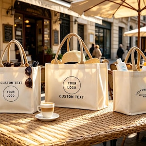 Peut inclure: Trois sacs fourre-tout en toile blanc cassé avec des anses en jute robustes. Le sac de gauche porte le texte CUSTOM TEXT et YOUR LOGO. Le sac central affiche YOUR LOGO et CUSTOM TEXT. Le sac de droite présente CUSTOM TEXT et SECOND TEXT HERE.