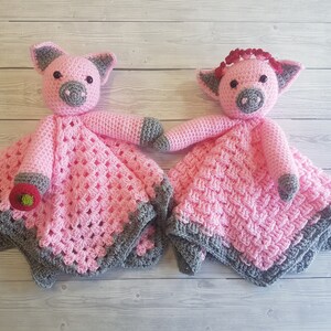 May include: Two pink crocheted pig baby blankets with grey trim. One pig has a red bow. Pattern by Crafting Happiness