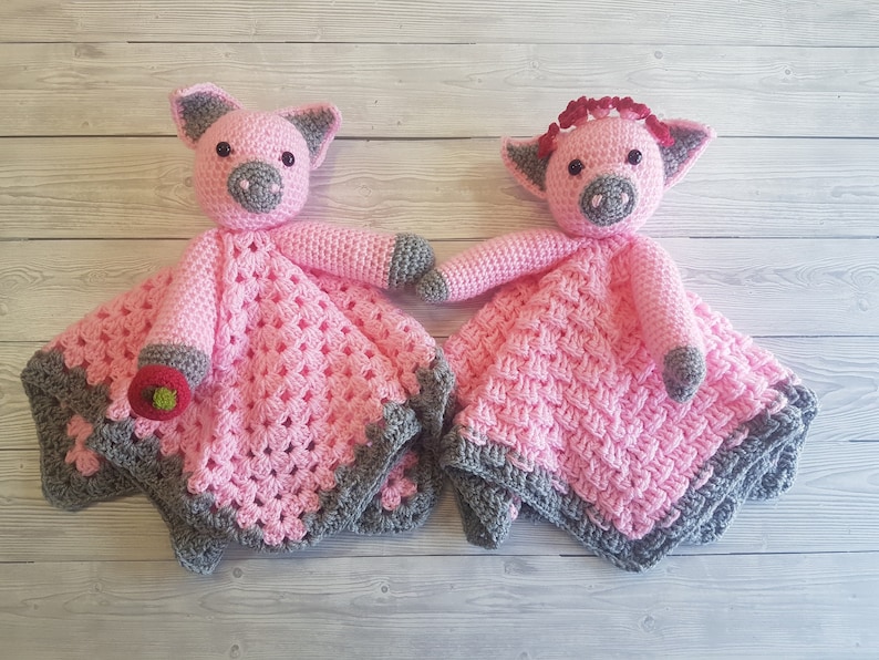 May include: Two pink crocheted pig baby blankets with grey trim. One pig has a red bow. Pattern by Crafting Happiness