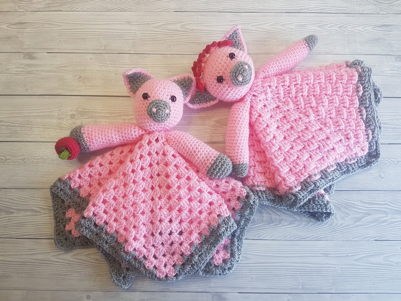 May include: Two pink crocheted pig baby blankets with grey trim. One pig has a red bow and the other has a red apple. Pattern by Crafting Happiness
