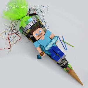 Könnte beinhalten: Ein brauner Papierkegel, der mit einem Minecraft-Charakter, einem grün-schwarzen Schwert und dem Wort "Minecraft" verziert ist. Der Kegel ist mit grünem und blauem Seidenpapier gefüllt und hat ein grünes Band um die Spitze gebunden.