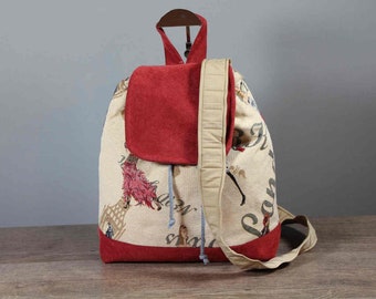 Könnte beinhalten: Ein beige-roter Rucksack mit einem tapisserieartigen Design, das eine Szene mit Menschen und Pferden zeigt. Der Rucksack hat eine rote Klappe mit einem Kordelverschluss und einen beigefarbenen Riemen.