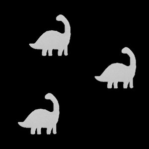 Op de afbeelding: Drie witte silhouetten van dinosaurussen op een zwarte achtergrond. De dinosaurussen kijken in verschillende richtingen.