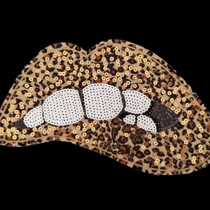 Könnte beinhalten: Ein dekorativer Aufnäher in Lippenform mit Leopardenmuster. Die Lippen sind mit goldenen Pailletten und weißen und schwarzen Perlen verziert, vor einem schwarzen Hintergrund.