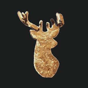 Könnte beinhalten: Ein goldener, mit Pailletten besetzter Hirschkopf-Anhänger. Der Hirschkopf ist eine traditionelle Weihnachtsdekoration.