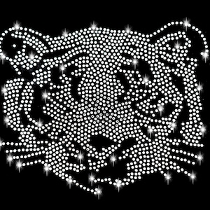 Op de afbeelding: Een wit strass-tijgergezichtsontwerp. Het tijgergezicht is gemaakt van kleine, ronde strasssteentjes die in een patroon zijn gerangschikt om de vorm van het tijgergezicht te creëren. De strasssteentjes glinsteren en reflecteren licht.