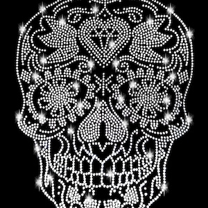 May include: A white rhinestone skull design with intricate floral patterns. The skull is made of small, sparkling rhinestones.