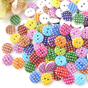 May include: Assortment of colourful wooden buttons with white polka dots. The buttons are round and have two holes.