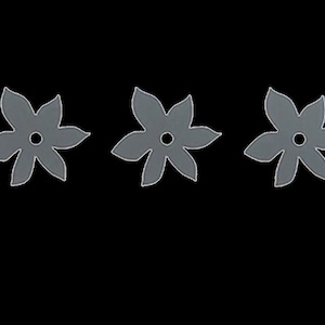 Può includere: Tre sagome di fiori di carta grigie con un foro al centro di ogni fiore.