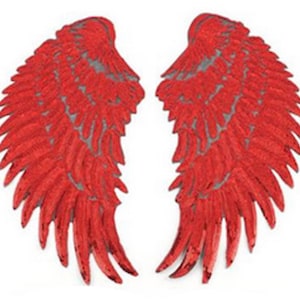 Könnte beinhalten: Ein Paar rote Pailletten-Engelsflügel. Die Flügel sind mit einem geschichteten Design verziert und haben ein schimmerndes Finish.